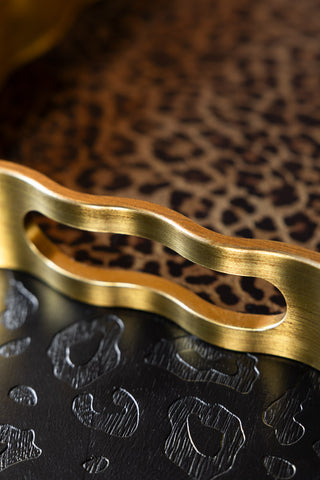 Close-up of the handle of one of the Set of 2 Gold & Leopard Serving Trays.