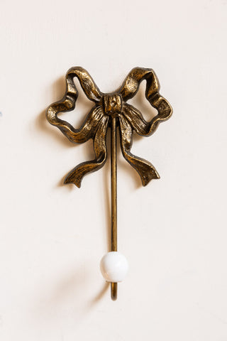 Image of the Set of 2 Pretty Gold Bow Wall Hooks on a wall