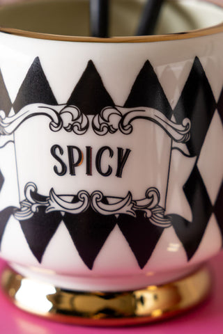 Close up of the Set of 2 Spicy & Dirty Cocktail Cups, showing the harlequin pattern and typography on the front of the spicy tumbler. 