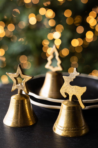 Lifestyle image of the Set of 3 Gold Bell Christmas Ornaments on a black surface.