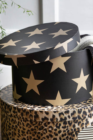 The Set of 3 Signature Storage Boxes in Stripes, Stars & Leopard Print shown with just the star and leopard designs in shot. The lid of the stars box is open, showing a scarf inside. 