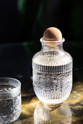 Close-up of one of the Set of 3 Vintage-Style Glass Carafes & Stacking Tumblers with a circle design.