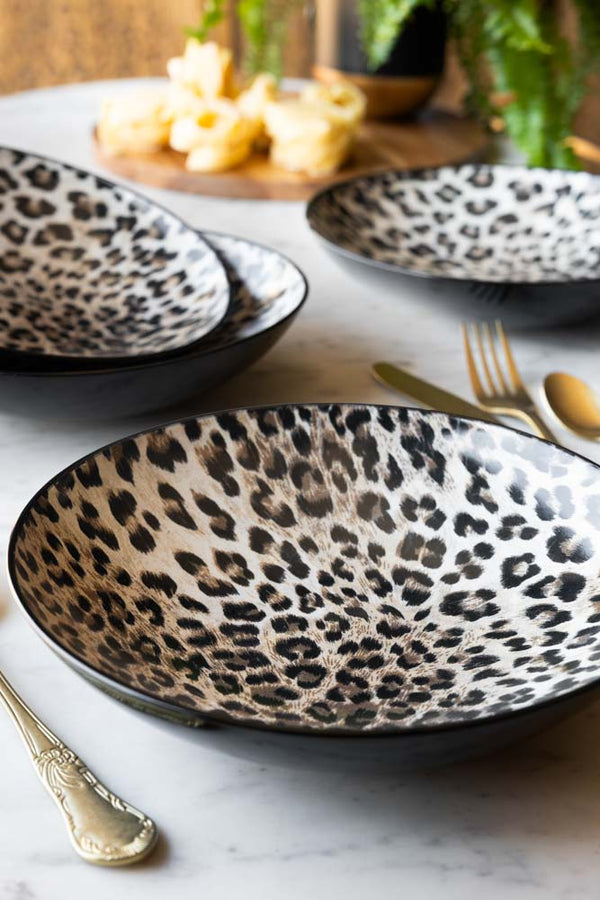 Set of 4 Leopard Print Pasta Bowls shown on a marble table with gold cutlery. 