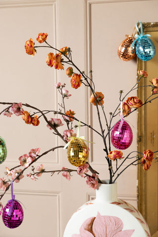 The Set Of 6 Colourful Disco Easter Egg Decorations styled on some branches.