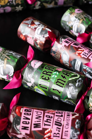 Rock n roll christmas crackers in green and pink lying on a dark table