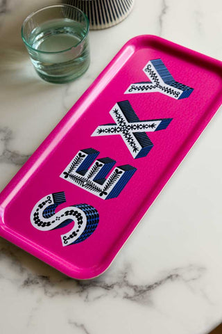 The Sexy Bright Pink Tray displayed on a marble surface with a glass.