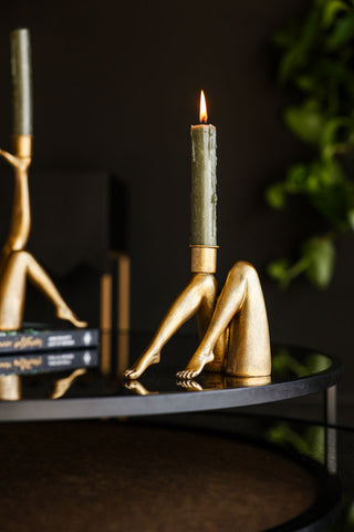 Sexy Gold Legs Candle Holder on a black table with the Kick Leg Candle Holder, styled with green candles