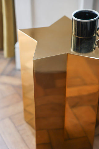 Lifestyle image of the Shiny Gold Star Side Table styled with a mug. 