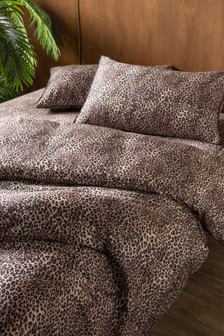The Signature Leopard Print Cotton Sateen Bedding Set styled on a bed with a matching leopard print sheet and a plant in the background.