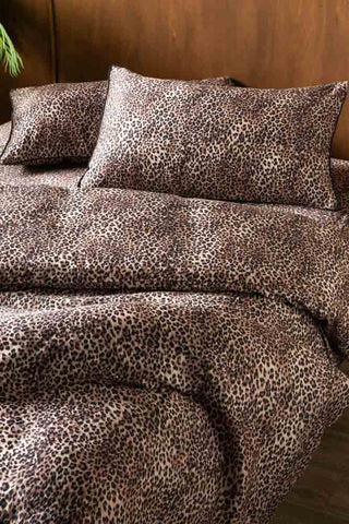 The Signature Leopard Print Cotton Sateen Bedding Setv sdraped on a bed.