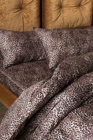 The Signature Leopard Print Cotton Sateen Bedding Set styled on a bed with a matching leopard print sheet.