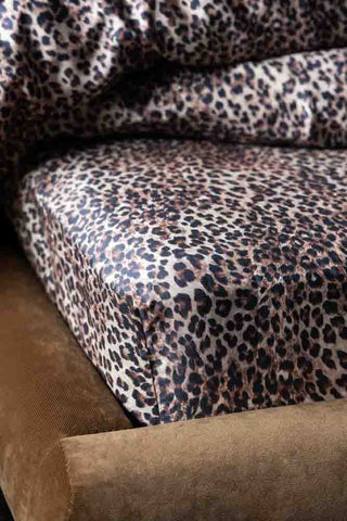 The Signature Leopard Print Cotton Sateen Fitted Sheet styled on a bed.
