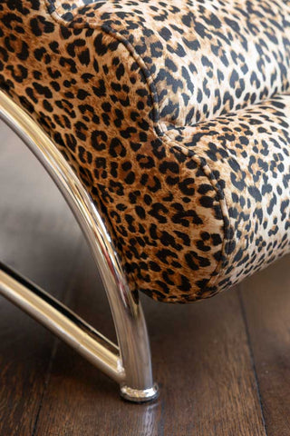 Detail of the chrome base against the leopard print velvet of the Signature Leopard Print Lounger Chair. 