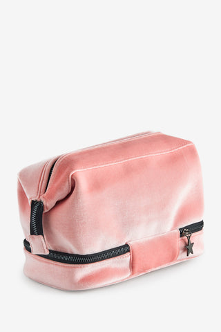 The back of the Sisterhood Blush Pink Velvet Washbag, shown from the side to show the pale pink velvet and the star zip at the bottom. 