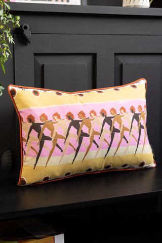The Sisterhood Charity Rectangular Cushion displayed on a black bench.