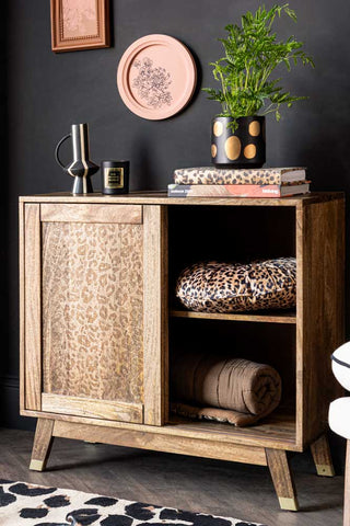 Natural Leopard Print Small Sideboard styled against a dark black wall and shown with the door open to reveal 2 shelves inside. 