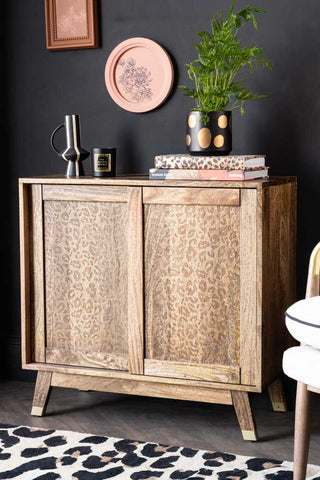 Natural Leopard Print Small Sideboard styled against a dark black wall with pink art on the walls. 