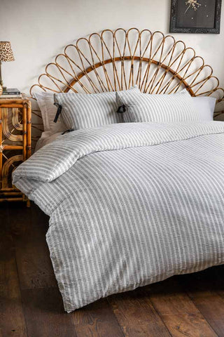 Starstruck Stripe Seersucker Bedding Set shown against a rattan bed frame with a matching rattan side table