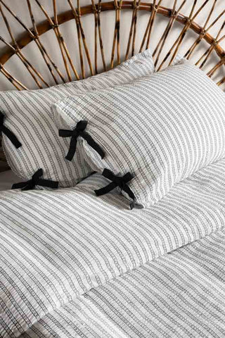 Close up of Starstruck Stripe Seersucker Bedding Set against a rattan bed frame