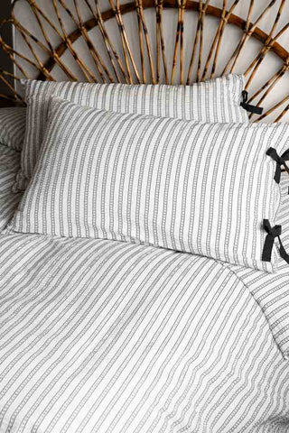 Starstruck Stripe Seersucker Bedding Set against a rattan bed frame, with focus on the pillows. 