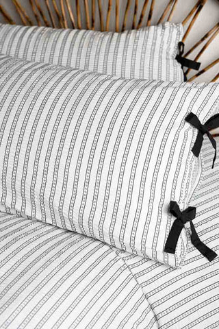Starstruck Stripe Seersucker Bedding Set with a focus on the black pillow ties against the monochrome star stripes. 