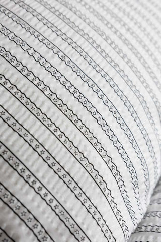 A close up of the star stripe pattern on the pillow of the Starstruck Stripe Seersucker Bedding Set.