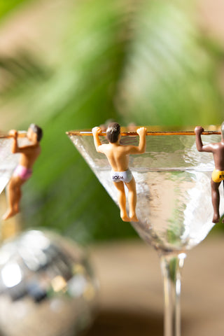 Some of the Set of 6 Hunky Buddies Wine Glass Charms styled hanging from a wine glass.
