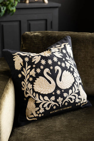 The Swan Tapestry Embroidered Cushion on a sofa.
