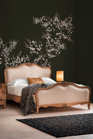 The Blossom Mischief Mural Wallpaper in Forest shown in a bedroom with a French-style bed. 
