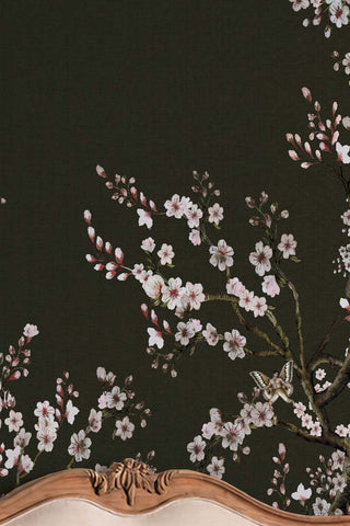 Detail of The Blossom Mischief Mural Wallpaper in Forest shown above a bed.