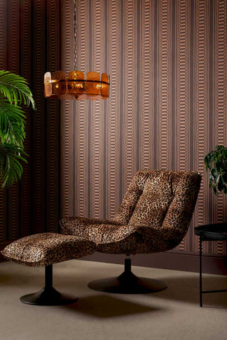 The Curiosity Shop Stripe Wallpaper in Aubergine shown with a leopard chair and footstool and an amber glass ceiling light.