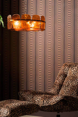 The Curiosity Shop Stripe Wallpaper in Aubergine shown in closer detail with a leopard chair, footstool and amber glass ceiling light. 
