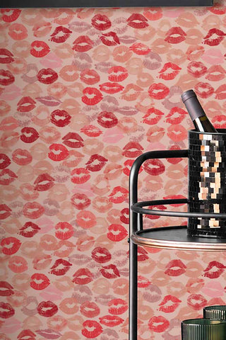 Close up of The Kiss Me Lipstick Wallpaper with a bar cart in the corner. 