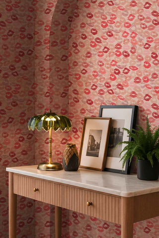 The Kiss Me Lipstick Wallpaper shown in a hallway with a wood and marble console table. 