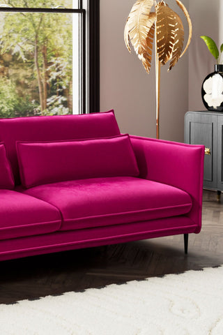 Close-up of one side of The Lola 4 Seater Sofa in Harry's Pink Velvet with various accessories around it.