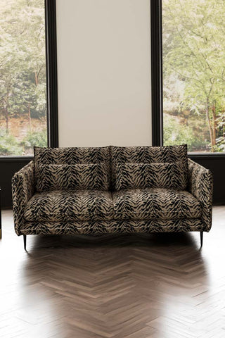 The Lola 3 Seater Sofa in Tiger Print Velvet styled in front of two windows.