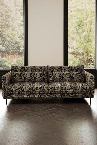 The Lola 4 Seater Sofa in Tiger Print Velvet styled in front of two windows.