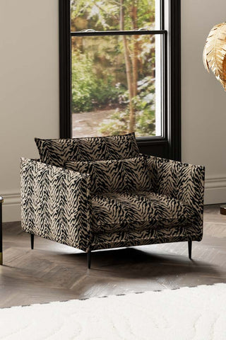 The Lola Snuggle Seat in Tiger Print Velvet styled with a rug, in front of a window.