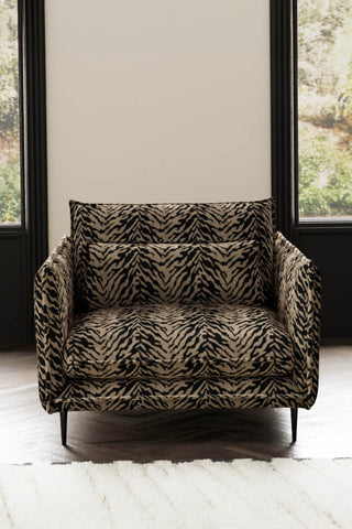 The Lola Snuggle Seat in Tiger Print Velvet styled with a rug in front of two windows.