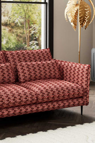 Close-up of The Lola 2 Seater Sofa in Woven Red & Pink Lips Velvet, styled with a floor lamp and window in the background.