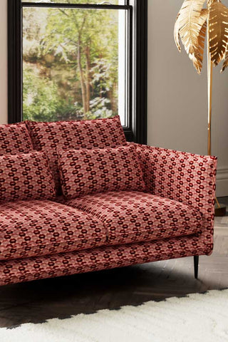 Close-up of one side of The Lola 4 Seater Sofa in Woven Red & Pink Lips Velvet, styled with a floor lamp and a window in the background.