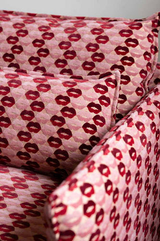 Close-up of the arm and cushions of The Lola Snuggle Seat in Woven Red & Pink Lips Velvet.