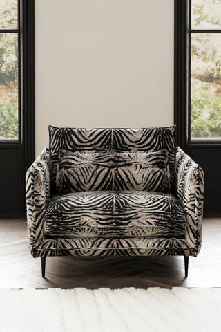 The Lola Snuggle Seat in Zebra Print Velvet styled with a rug in front of two windows.