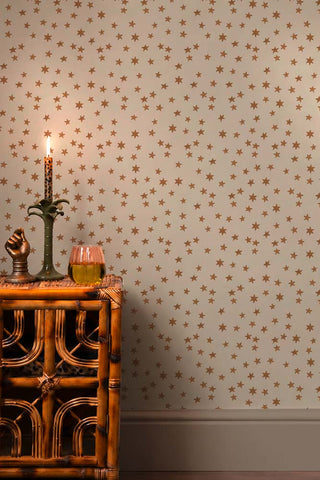 The Midnight Skies Wallpaper in Ivory shown with a bamboo cabinet.
