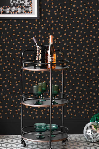 The Midnight Skies Wallpaper in Noir shown with a bar cart styled with glasses. 