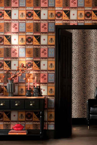 The Perfect Match Wallpaper in Golden Hour shown in a hallway with a console table and an open door leading to a leopard print living room. 
