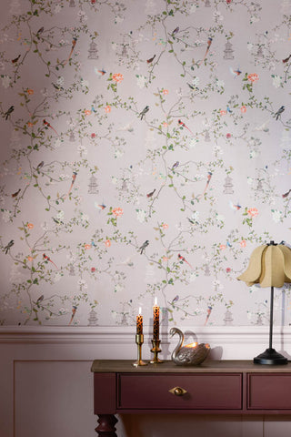 A close up image of The Secret Garden Chinoiserie Wallpaper in Dusty Lilac shown in a hallway with a console table.