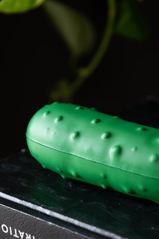 Close-up of the The Stress Pickle displayed on a black book.