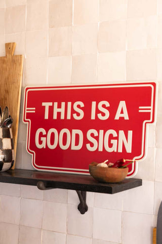 Red sign with 'This is a good sign' text in a kitchen setting