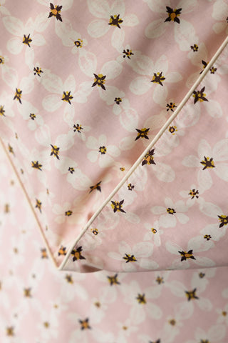 Close-up of the design and piped edge of the Blush Pink Daisy Bedding Set with Piped Edge.